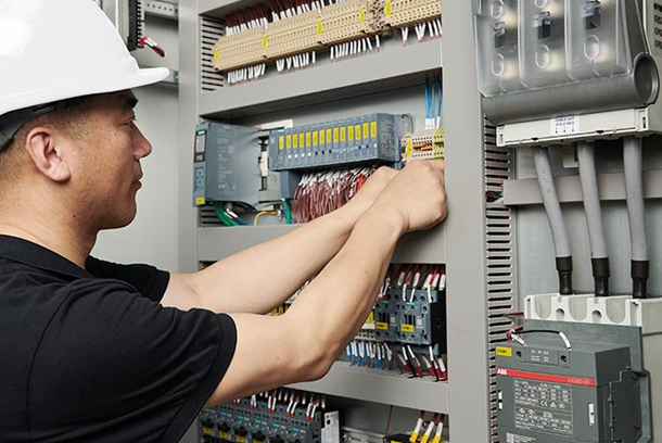 Technician working on the electrical panel of a Fulcrum vacuum furnace